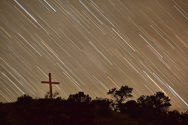 Star trails behind the cross